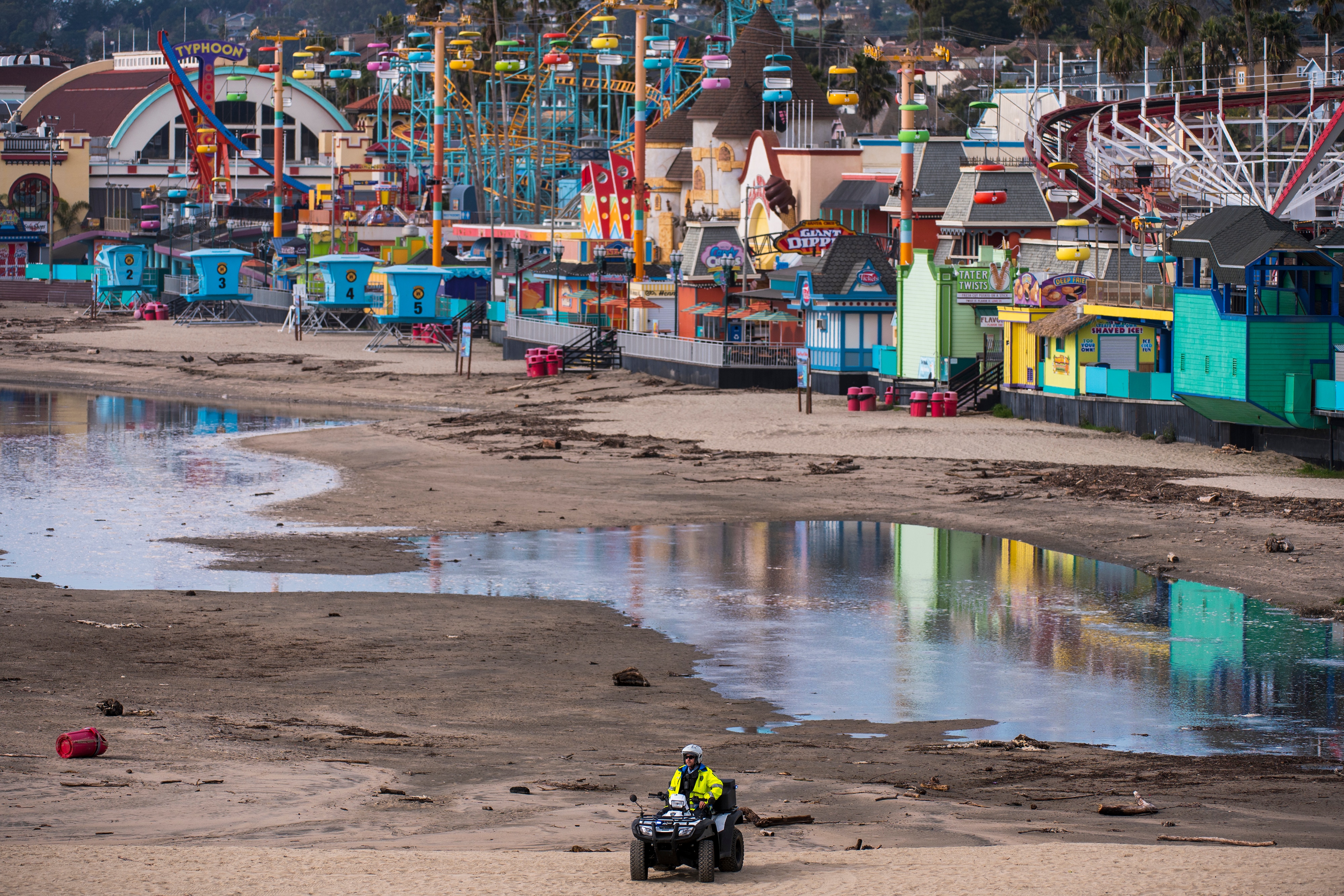 A police officer patrols the beach as waters recede in front of the Santa Cruz Beach Boardwalk in Santa Cruz, Calif., Saturday, 15 January, 2022.