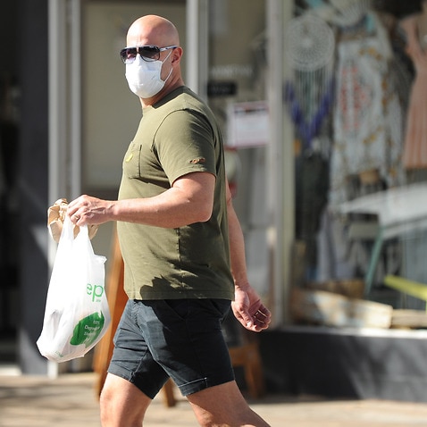 A man wears a mask to Cronulla Mall in Sydney, Saturday, March 28, 2020. 