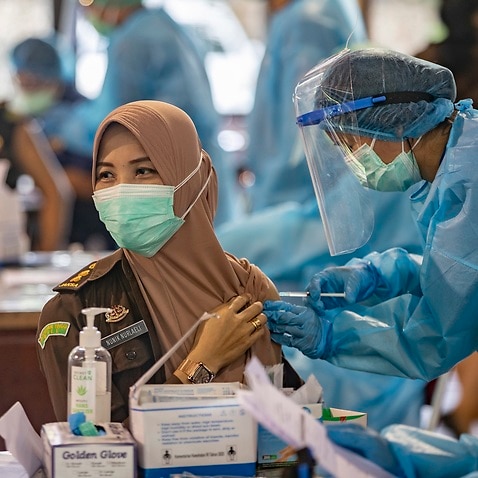 A woman receives a shot of the COVID-19 vaccine during a vaccination drive in Denpasar, Bali, Indonesia on 9 March 2021.  