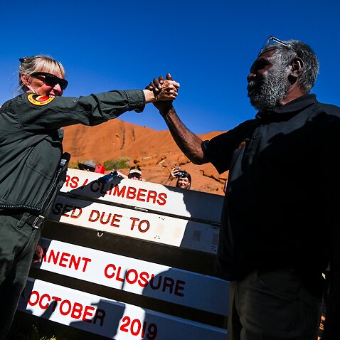 Mlinzi Lynda Wright (kushoto) na Mwenyekiti wa baraza la Uluru-Kata Tjuta Sidney James (kulia) waamkiana baada yakutekelezwa kwa marufukuyakupanda Uluru