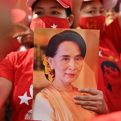 A Myanmar migrant holds up an image of Aung San Suu Kyi during a demonstration outside the Myanmar embassy in Bangkok on 1 February 2021.