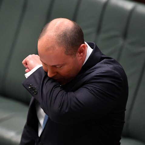 Treasurer Josh Frydenberg has a coughing fit as he makes a ministerial statement to the House of Representatives at Parliament House in Canberra