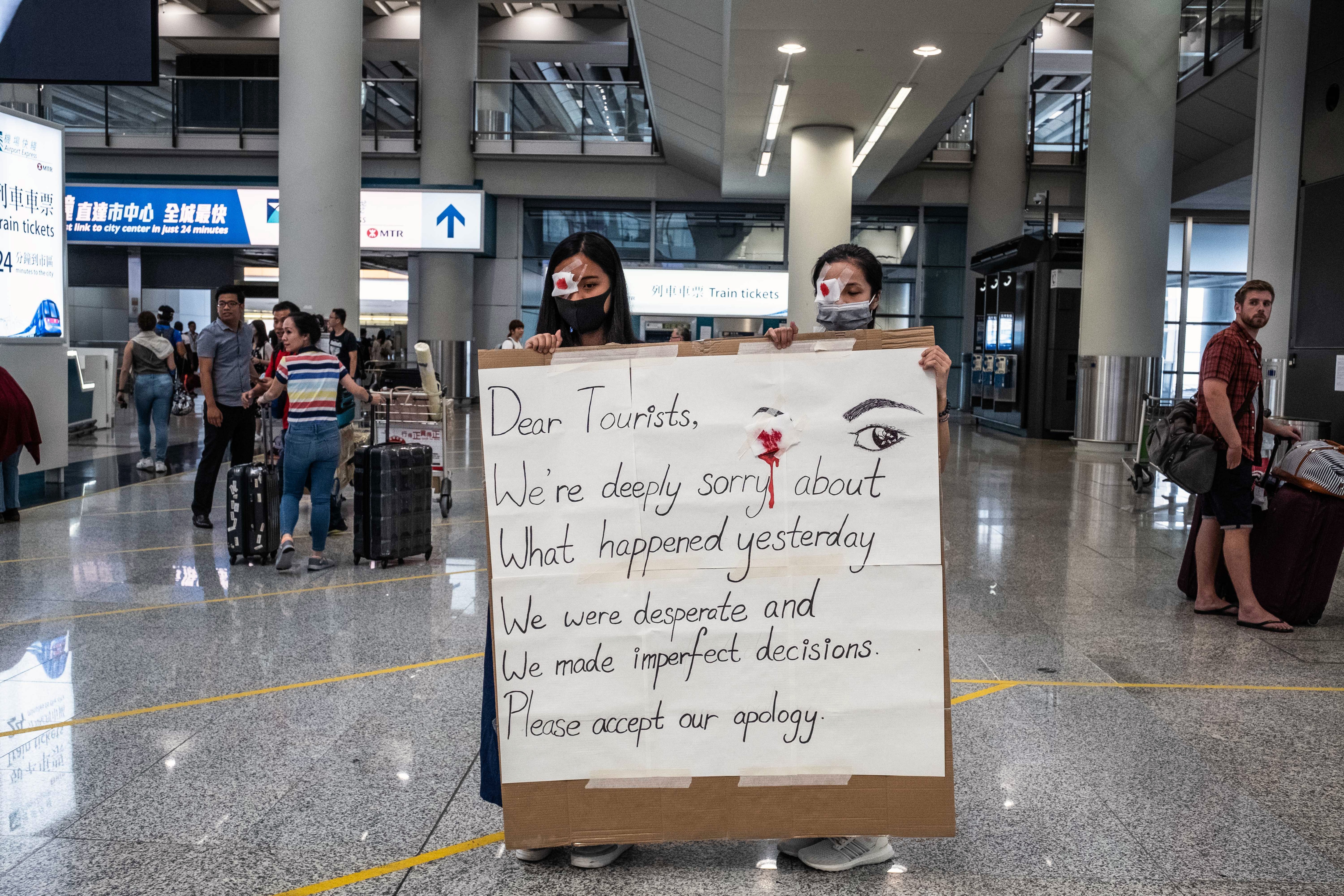 At the Hong Kong International Airport on Wednesday, Aug. 14, 2019, protesters offer travelers apologies, aware of the negative image they had presented in scuffles the day before.  (Lam Yik Fei/The New York Times)