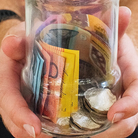 Image of a man holding Australian fiat money.