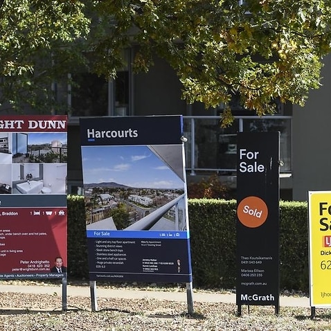 'For sale' signs are seen outside an apartment block in Canberra.