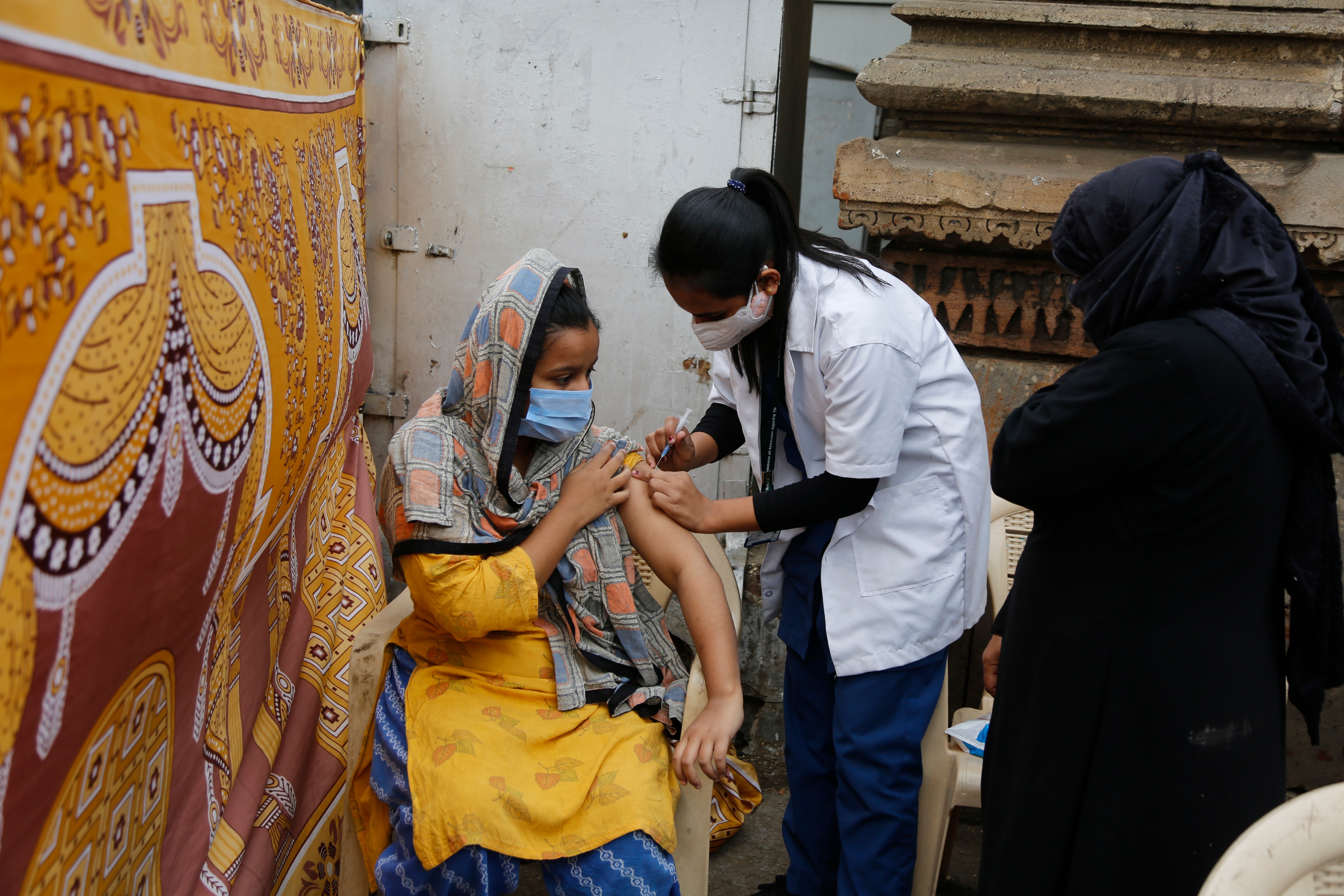 A health worker administers the vaccine for COVID-19 to a woman in Ahmedabad, India.