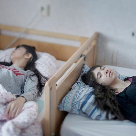 Two motionless sisters as they battle resignation syndrome in Sweden.