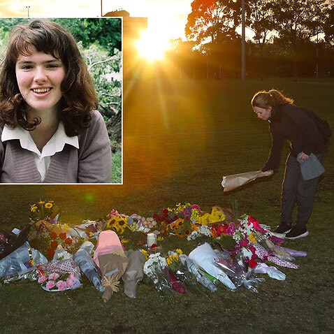 A woman places flowers at a growing makeshift memorial for Eurydice Dixon at the Princes Park sporting precinct in Melbourne.