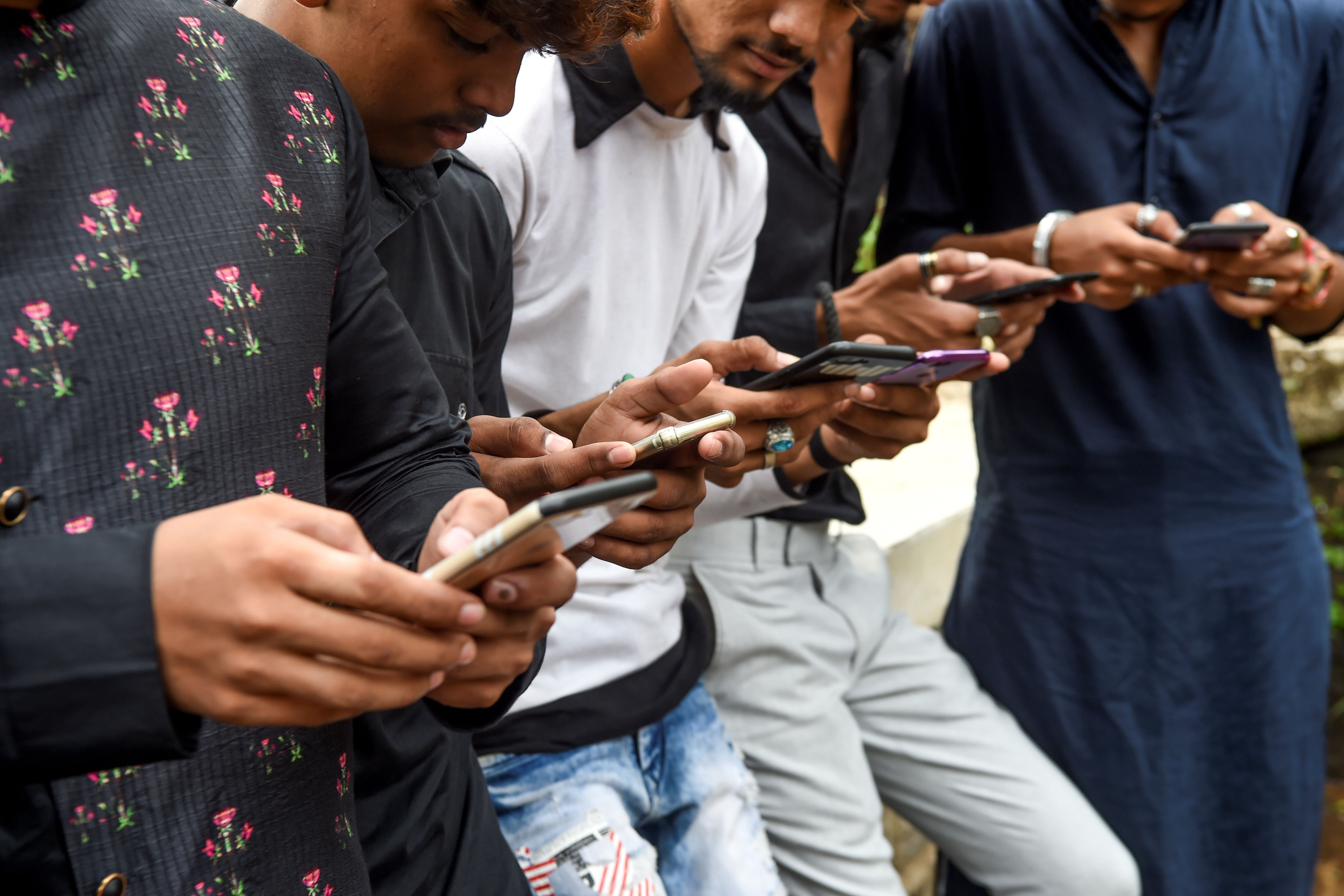 Youths watching videos on video-sharing app TikTok on their mobile phones in Mumbai. Youths watching videos on video-sharing app TikTok on their mobile phones in Mumbai.