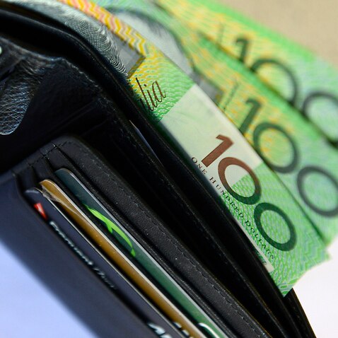 $100 Australian dollar notes pop out of a wallet with credit cards, pictured in Brisbane, Tuesday, Aug. 20, 2013. (AAP Image/Dan Peled) NO ARCHIVING