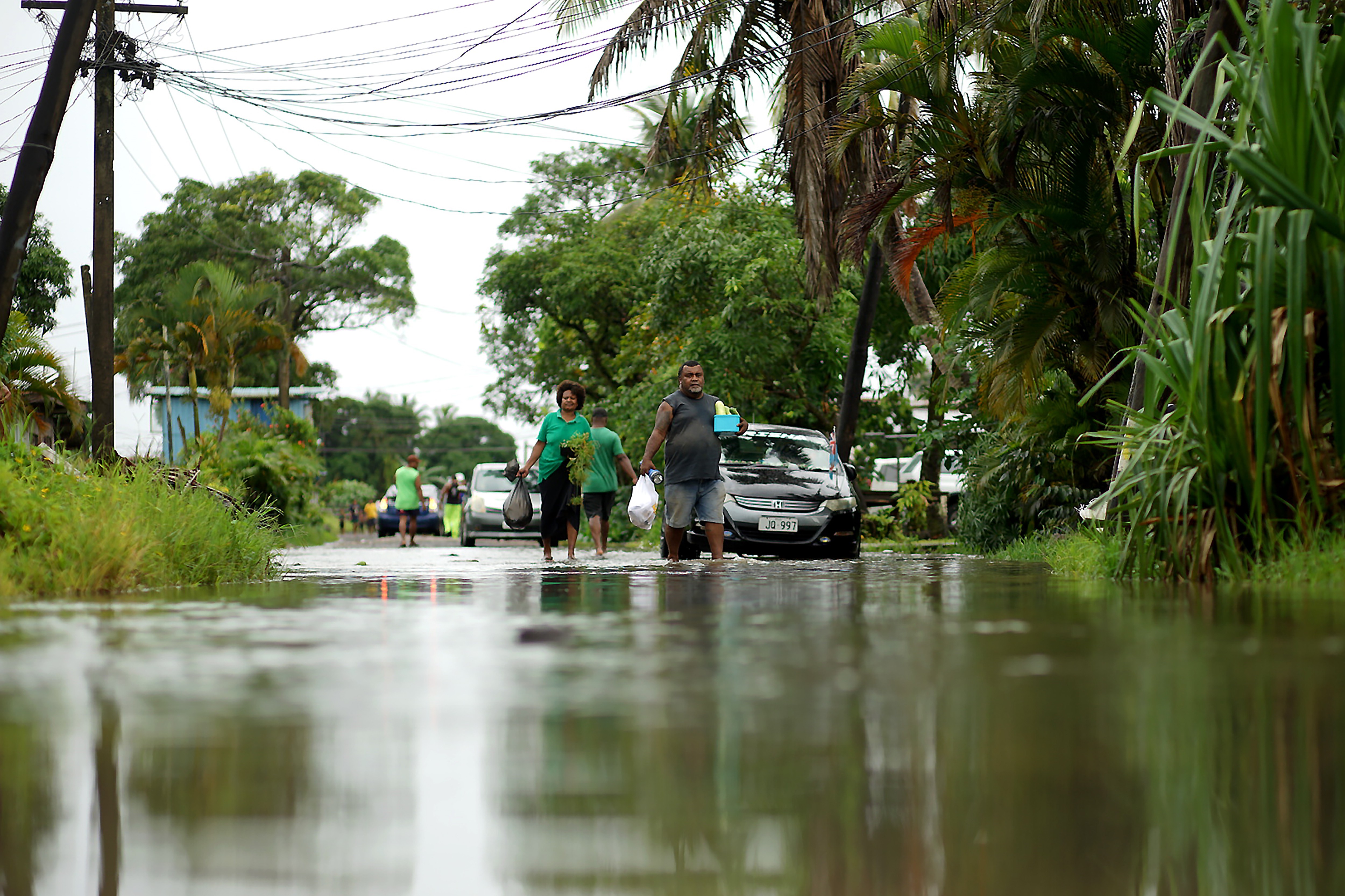 Residents wade through flooded streets in Suva in December 2020.