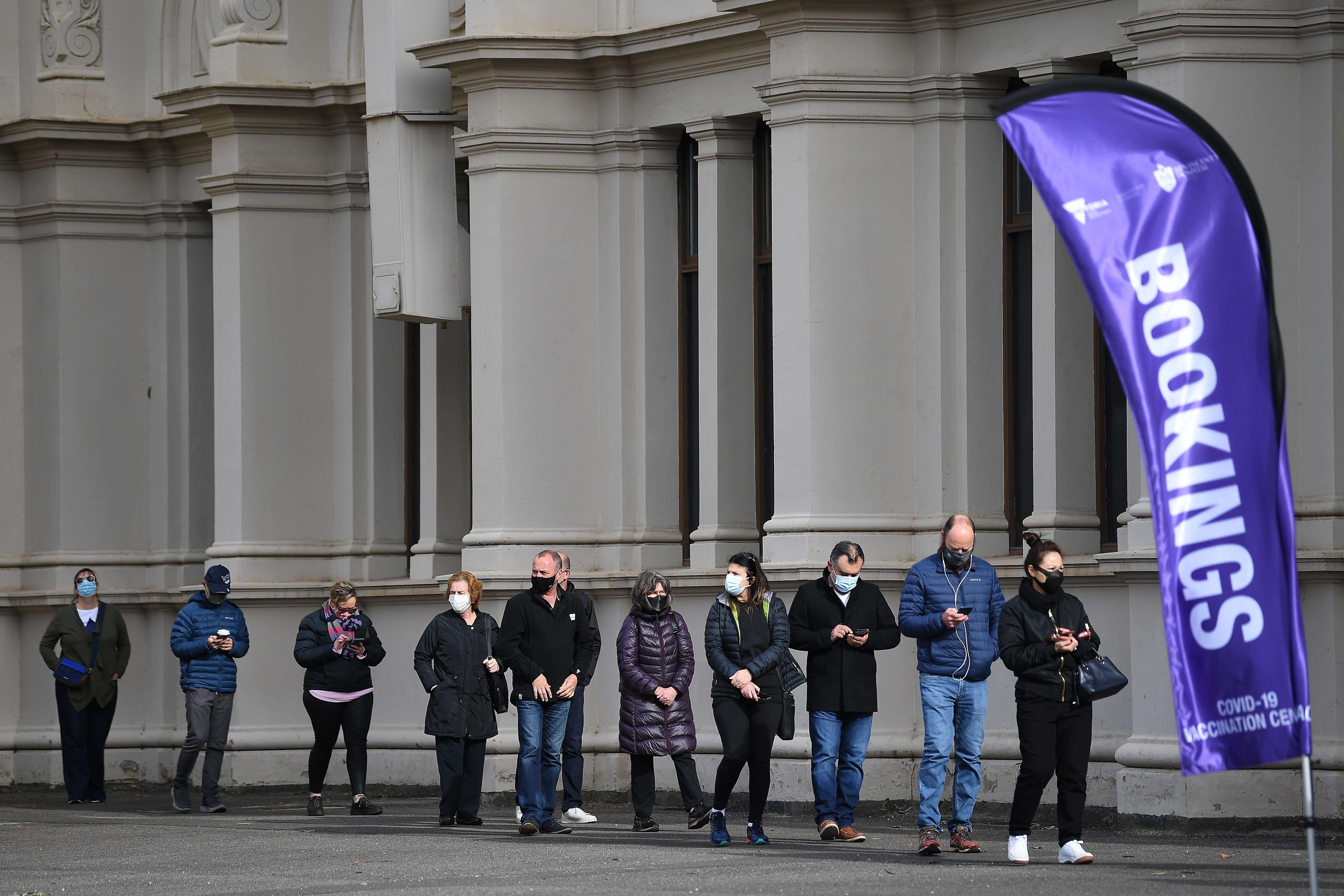 People queue outside the Melbourne Exhibition Centre coronavirus vaccination hub.