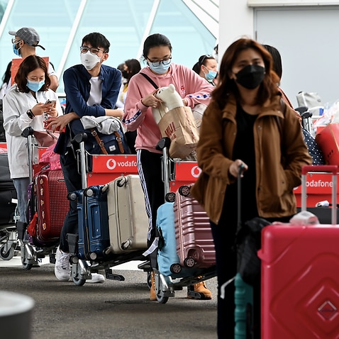 International students wear face masks as they arrive at Sydney Airport, 6 December 6 2021.
