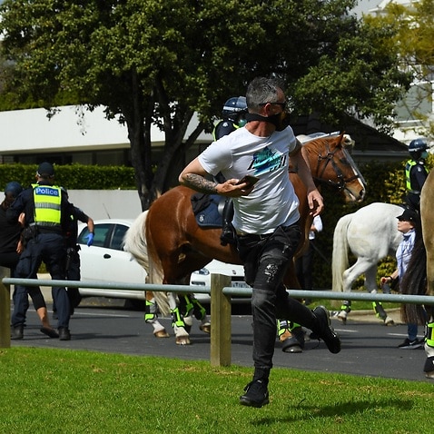 Protesters run from Victoria Police following a protests in Elsternwick Park in Melbourne.