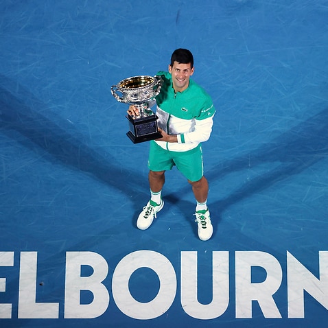 Serbia's Novak Djokovic holds the Norman Brookes Challenge Cup after defeating Russia's Daniil Medvedev in the men's singles final at the 2021 Australian Open 