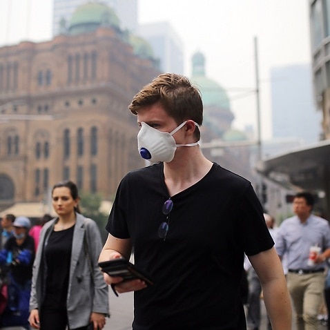 Pedestrians wear masks as smoke haze from bushfires hits Sydney.