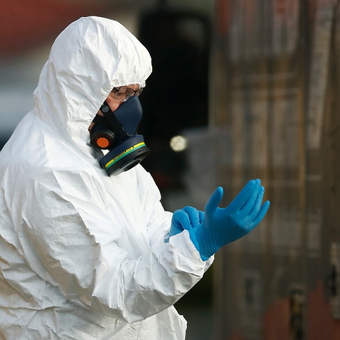 Clinical waste removal personnel are seen at St Basil’s Homes for the Aged in Fawkner, Melbourne, Friday, July 31, 2020. (AAP Image/Daniel Pockett) NO ARCHIVING