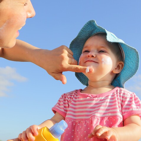 Mother applying sunscreen to child