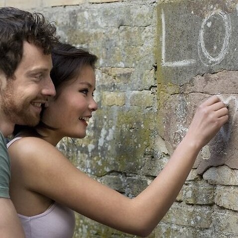 Girlfriend writing LOVE on a wall
