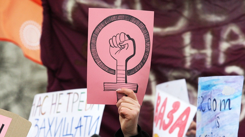 A woman holds a placard with a symbol of feminism during the feminist's Women March which is dedicated to International Women's Day in downtown Kiev.