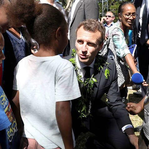 French President Emmanuel Macron speaks with children in New Caledonia on May 5, 2018.