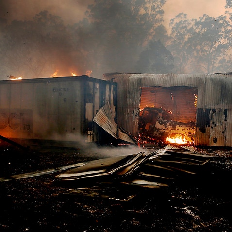 A vehicle burns inside a shed on a property at Possum Brush in the Mid North Coast region of New South Wales.