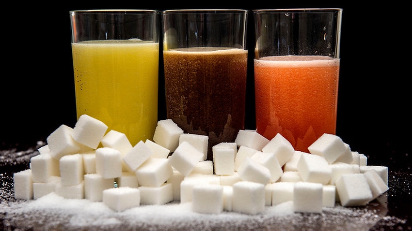 Carbonated drinks surrounded by sugar cubes.