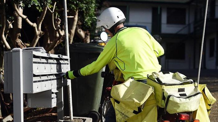 A postman on a motorbike delivers letters in Brisbane, Friday, June 26, 2015. Australia Post announced today it is setting aside $190 million to cover voluntary redundancy payments over the next three years, with 1900 jobs reportedly set to go as the gove