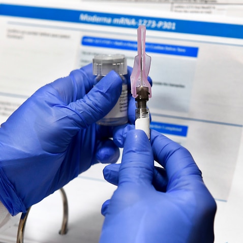 A nurse prepares an experimental vaccine for COVID-19 developed by the National Institutes of Health and Moderna Inc. at the United Health Services facility.