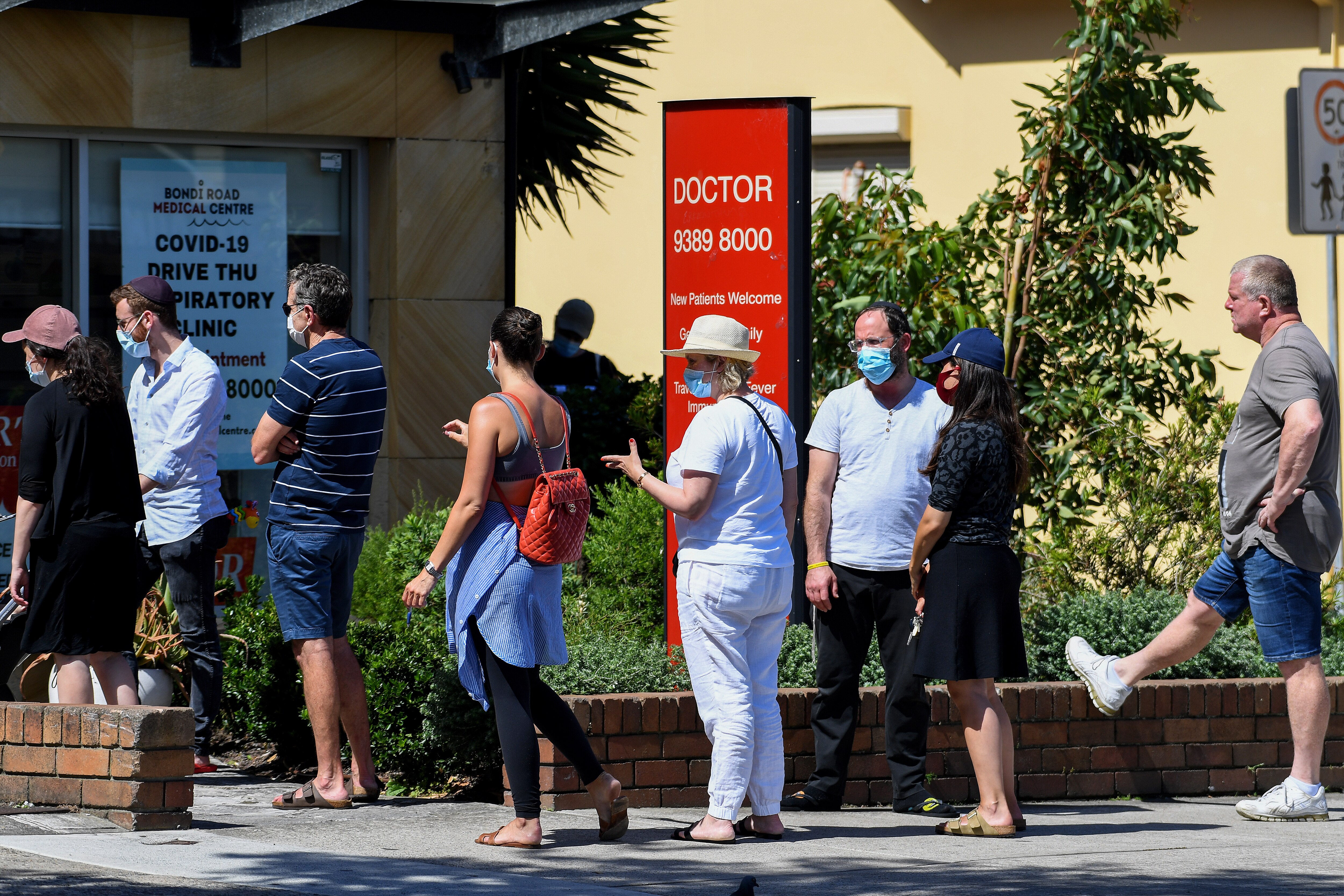 People queue for a COVID-19 PCR test at a doctors surgery in Sydney.