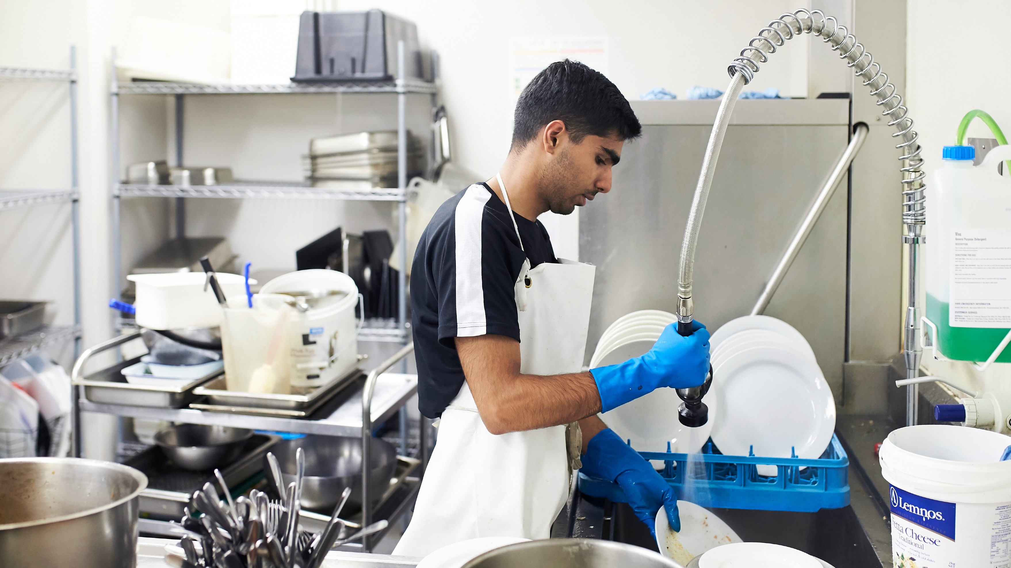 Man washing dishes in a commercial kitchen