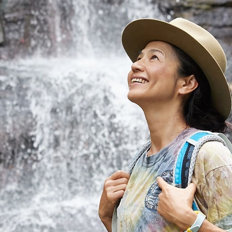 Mayumi Kataoka standing next to a waterfall