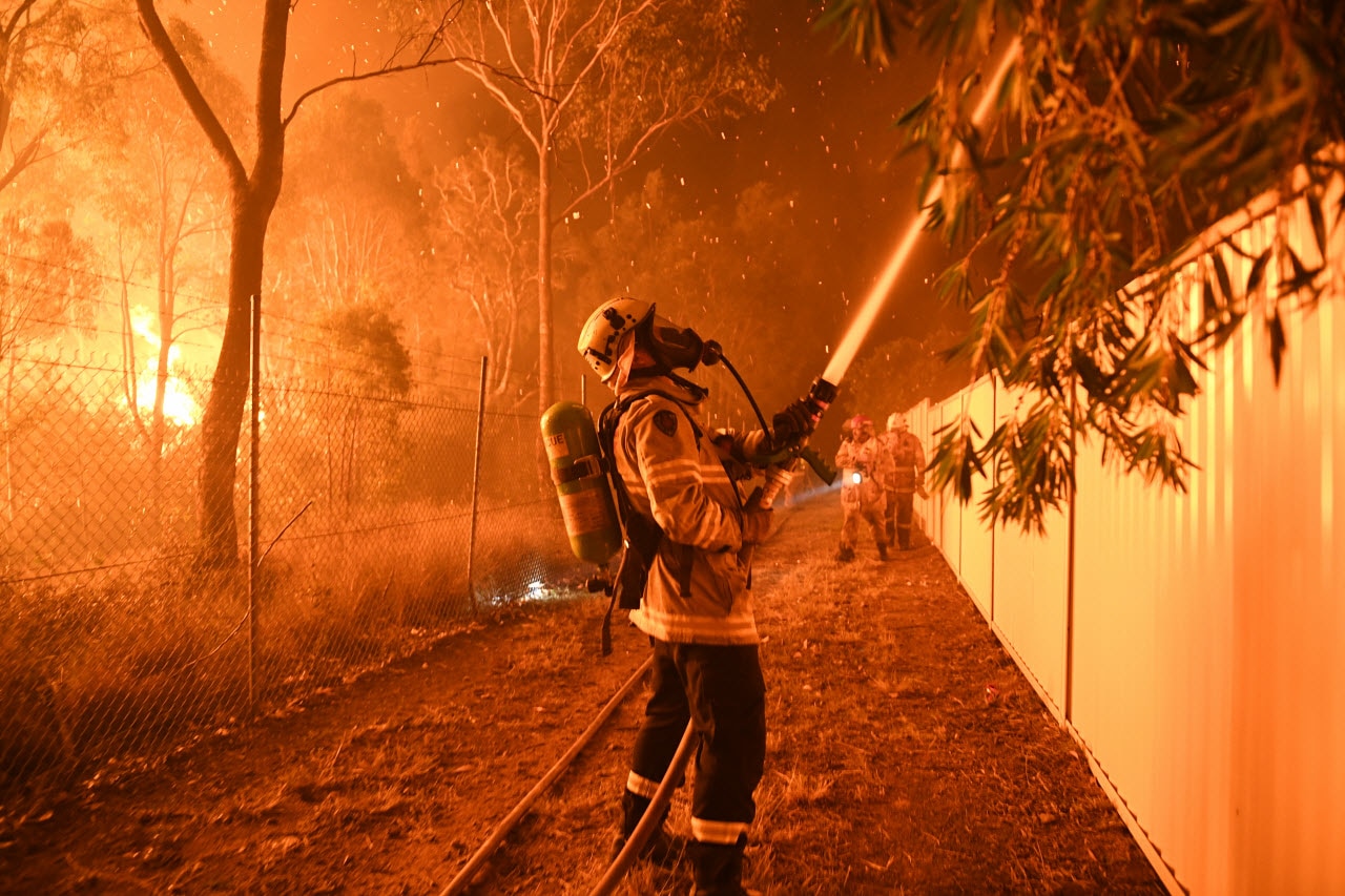 Firefighters fight flames close to homes in Corryton Court, Wattle Grove in Sydney.