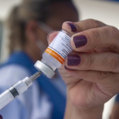 A doctor prepares to administer a dose of the Oxford-AstraZeneca vaccine