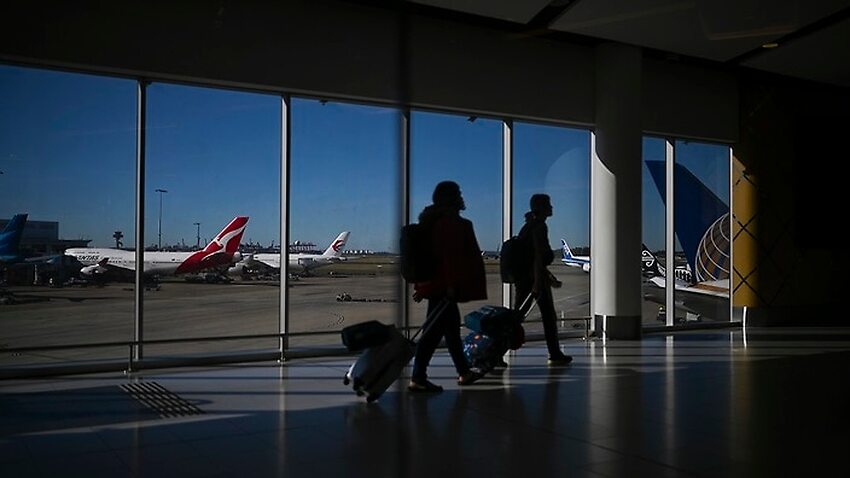 A Qantas plane is seen as passengers walk to their flights at Sydney International Airport in Sydney.
