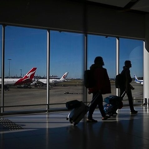 A Qantas plane is seen as passengers walk to their flights at Sydney International Airport in Sydney.