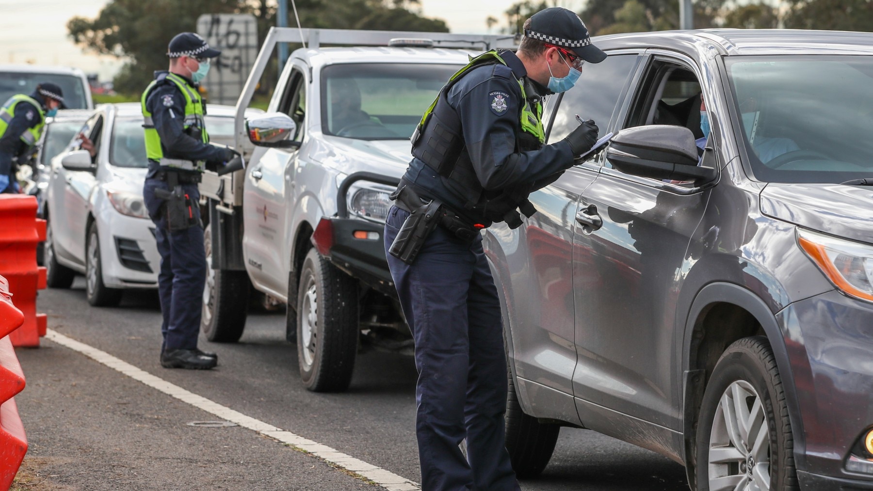 Police check permits and ID of drivers at a checkpoint in Victoria.