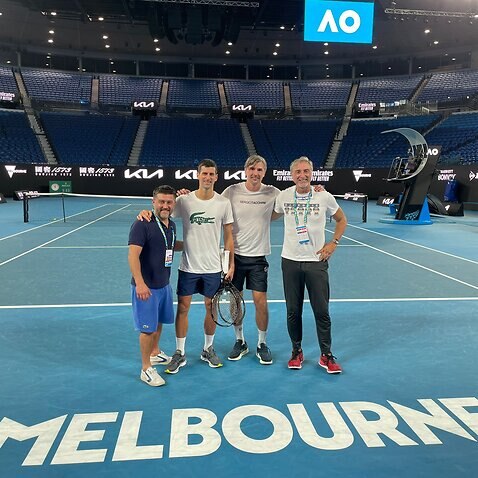 Novak Djokovic and his team pose on the Melbourne Park's court on Monday night 