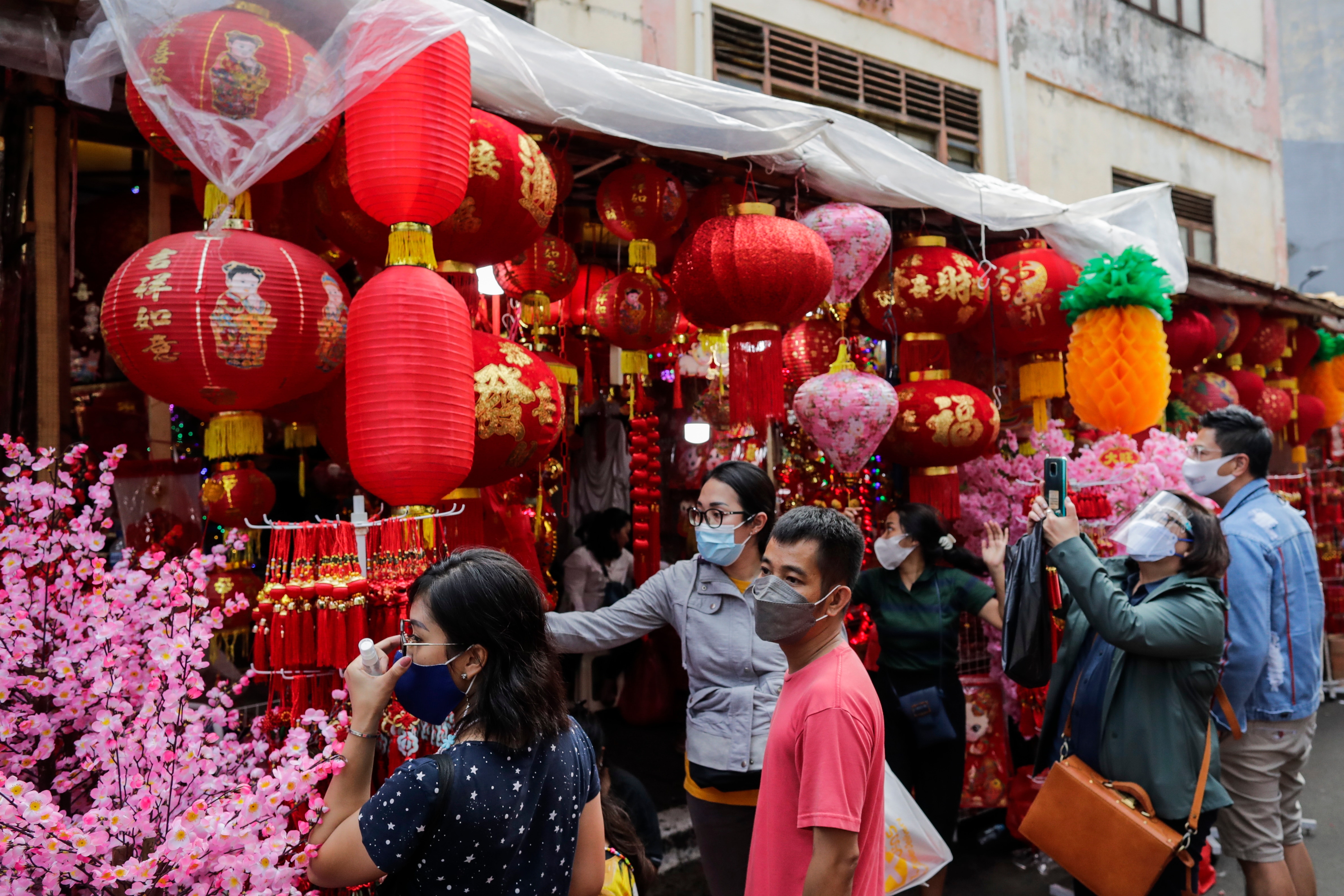 Customers shop for decorations for the upcoming Chinese Lunar New Year at a street side stall in Jakarta, Indonesia.