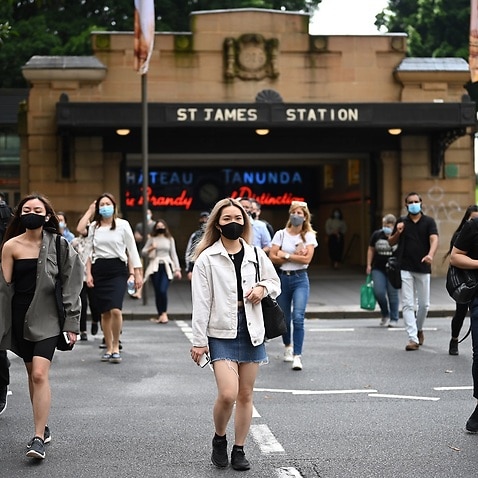 Commuters wearing face masks exit St. James Station in the CBD in Sydney, Monday, January 4, 2021. 