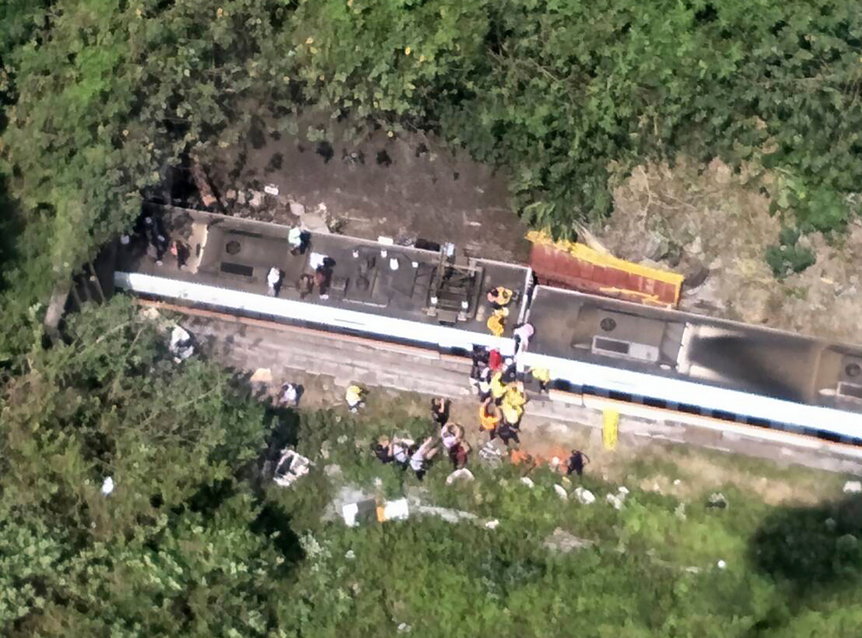 Rescue workers are seen near the site of a partial train derailment in Toroko Gorge in Taiwans eastern Hualian region on 2 April, 2021. 