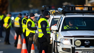 NSW Police officers check cars crossing from Victoria into New South Wales at a border check in Albury, NSW, Wednesday, July 8, 2020