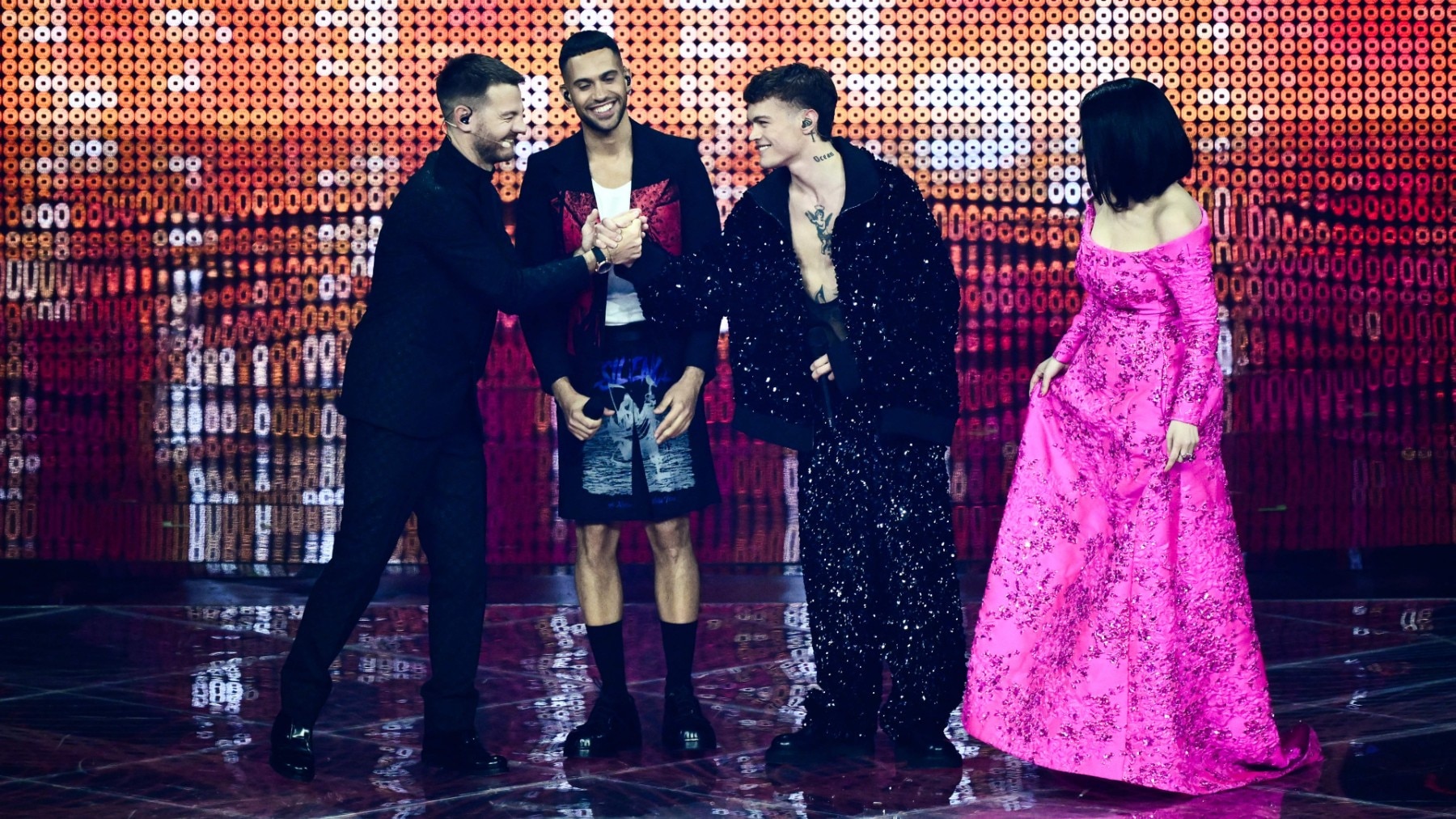 Eurovision 2022 presenter Alessandro Cattelan (L) taps hand with Italian singer Blanco (2ndR) as Italian singers Mahmood (2ndL) and Laura Pausini