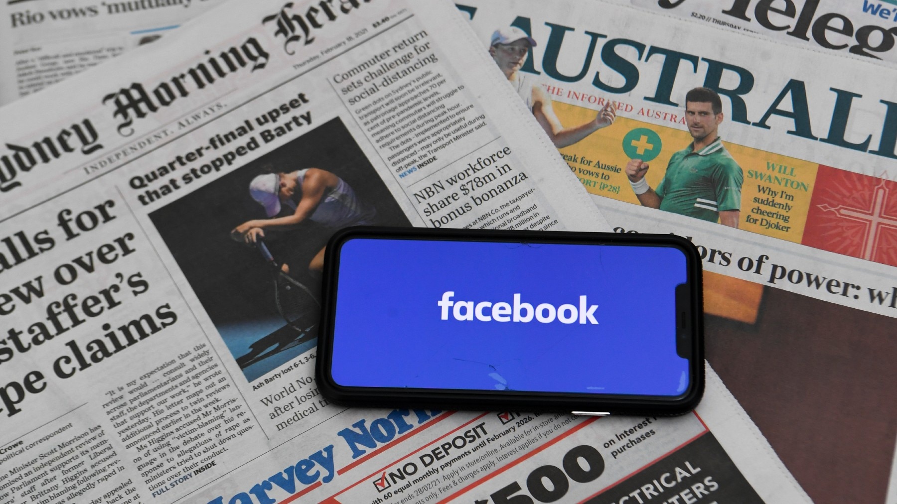 An illustration image shows a phone screen with the ‘Facebook’ logo and Australian Newspapers at Parliament House in Canberra, Thursday, February 18, 2021. Social media giant Facebook has moved to prohibit publishers and people in Australia from sharing o