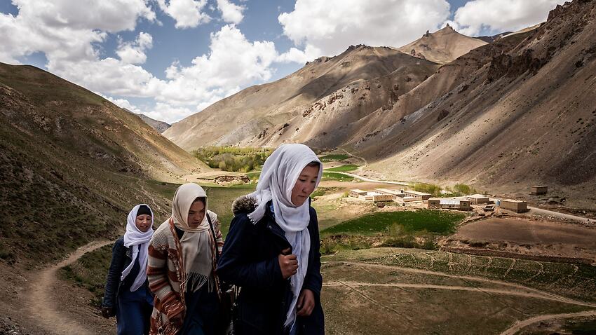Students of the Rustam School walking home last month on a single track over the mountains, the school standing behind them.