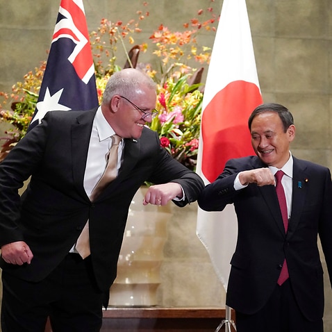 Australian Prime Minister Scott Morrison, left, greets with Japan's Prime Minister Yoshihide Suga