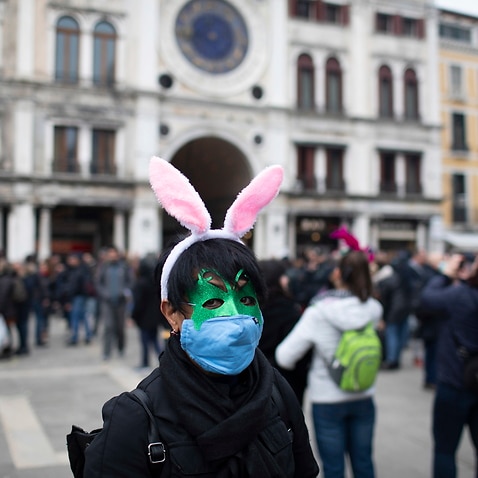 Tourists wear protective face masks during the Carnival in Venice The carnival has been cancelled over concerns of the spread of virus in northern Italy.