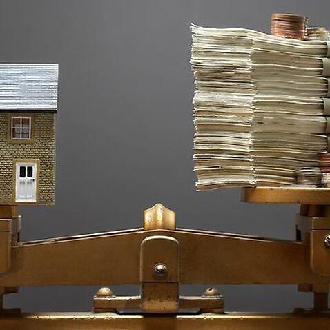 Model house and money on scales