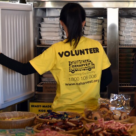 A volunteer helping a customer in the frozen food section of OzHarvest Market, a recycled food supermarket, in Sydney.