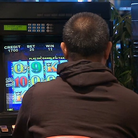 A man playing a poker machine 